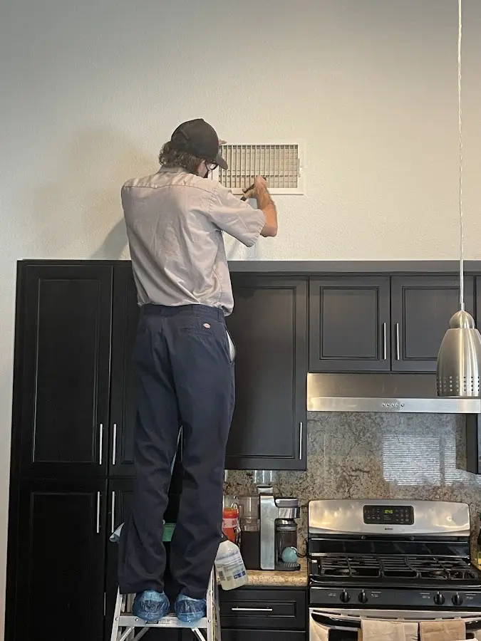 Technician inspecting an air vent during HVAC service in Binghamton